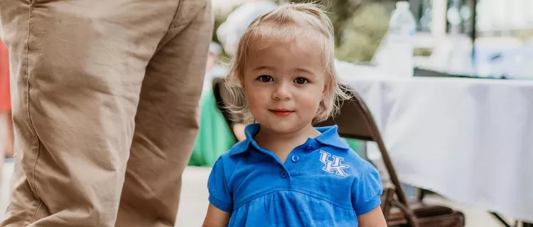 A child wears a UK outfit at a CAFE welcome event