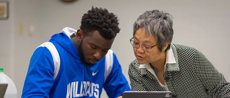 Keiko Tanaka helps a student at a desk