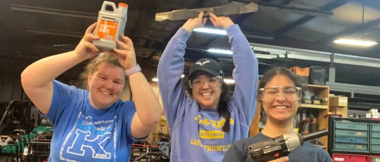 BAE Student Branch members hold tools in a workshop