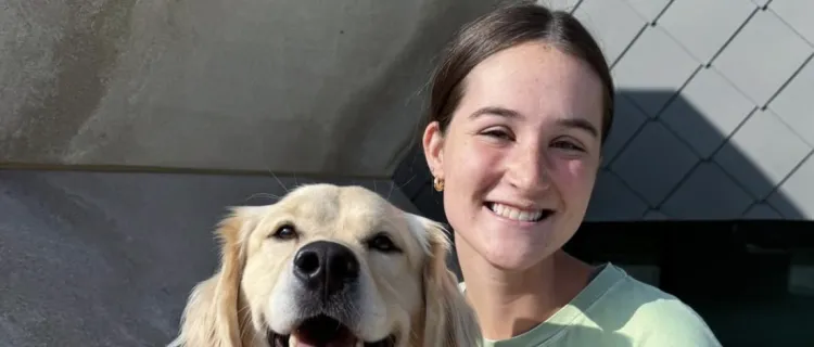 A Kentucky 4 Paws for Ability member smiles with a dog