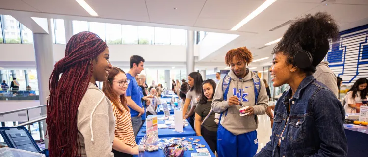Students talk at an event table