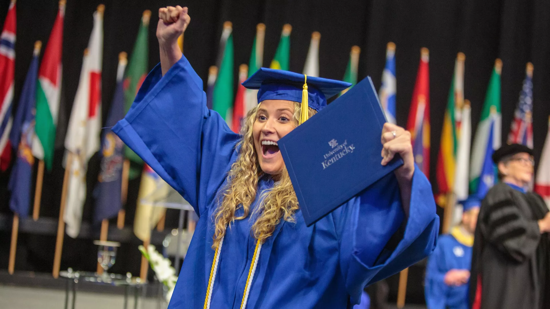 A graduate celebrates with their diploma