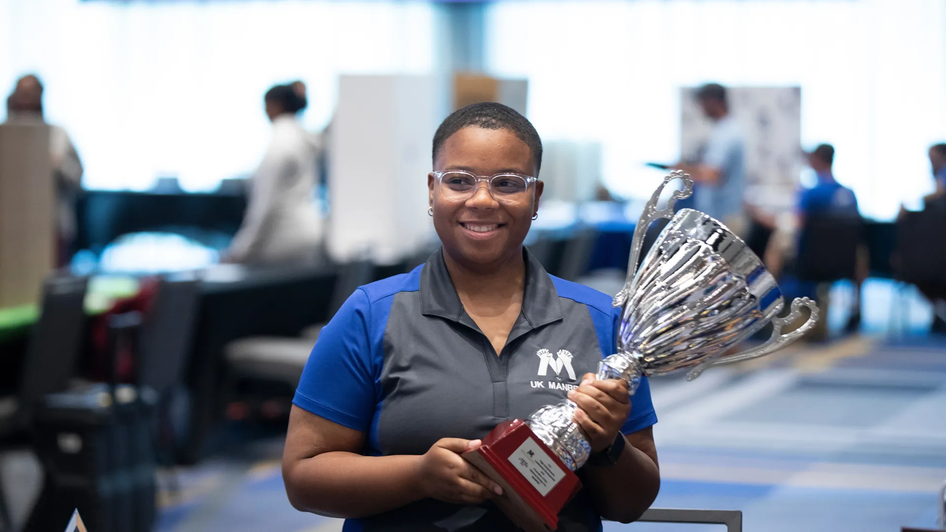A person holds a trophy at the MANRRS Involvement Fair