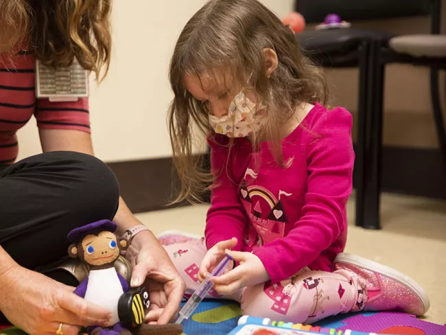 An adult and child play during therapy