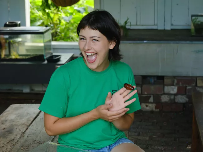 Student holding a beetle