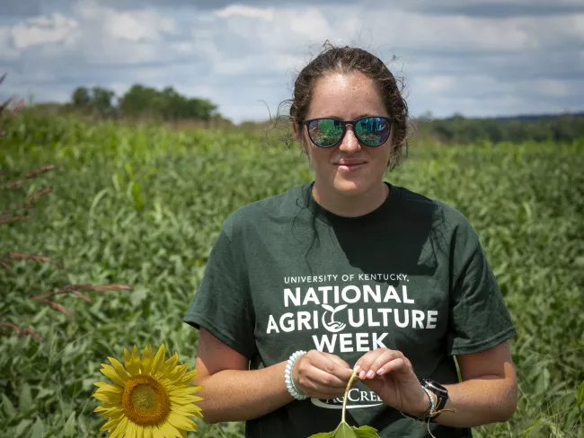 Agricultural Ecosystem Sciences Summer Experience Kate holding a Sunflower