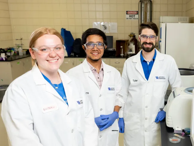 Three students work in a lab