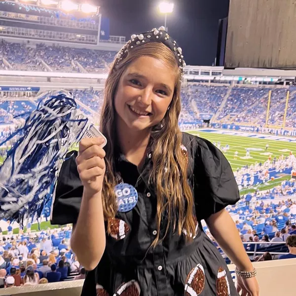 Kayleigh Thomas holds a pompom at a football game