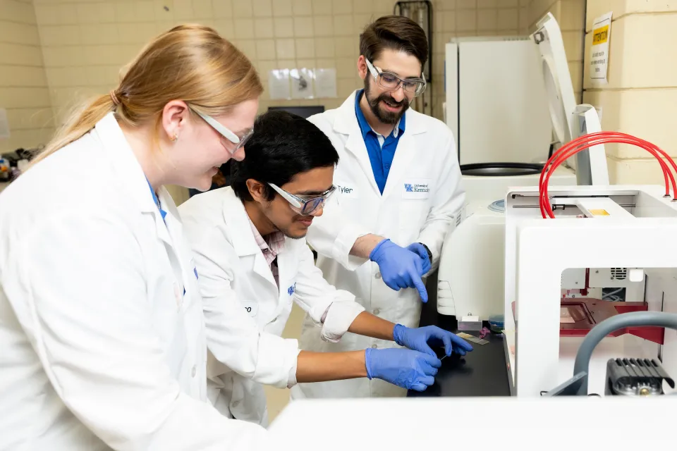 Three students work in a lab