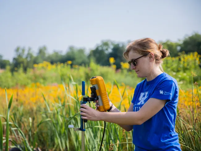 Student checking readings during Alumni Dr Stream Restoration Project